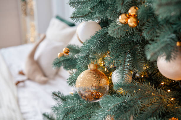 istock Decorated Christmas tree with golden ornaments in cozy indoor setting 2185301508