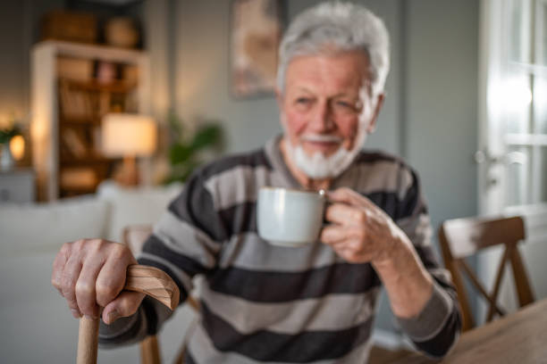 istock A look into the past. Grandfather drinking coffee, pensive with a walking cane 2185301740