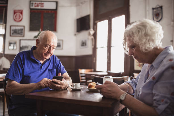 istock Elderly Couple Enjoying Coffee and Technology in Cafe 2185302938