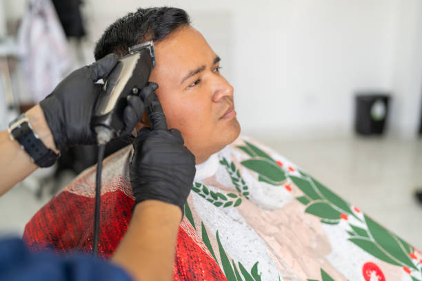 istock Unrecognizable barber using electric razor to cut hair of client 2185305290