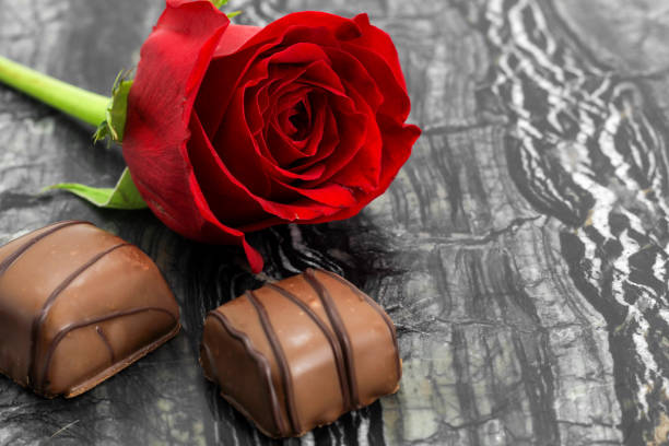 Roses and chocolates closeup on marble background, valentine's day