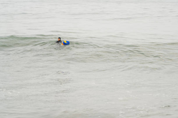 istock Fisherman in wetsuit floating on a clam sea 2185316175