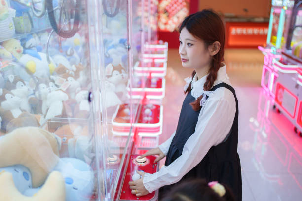 istock Young woman playing claw machine 2185316798