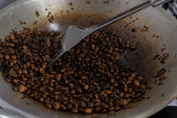 roasting coffee beans in a pan, a traditional technique in making fragrant coffee roasting