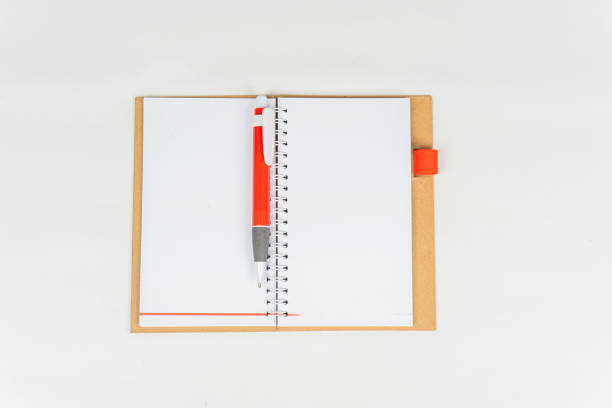 a blank notebook with a red pen on top of it on white background.