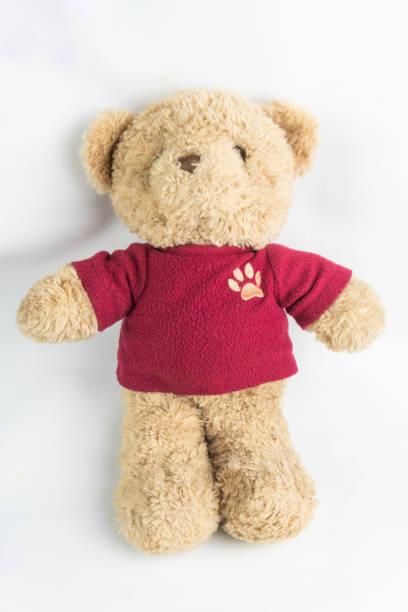 istock A teddy bear wearing a red shirt lies on a white background 2185322915