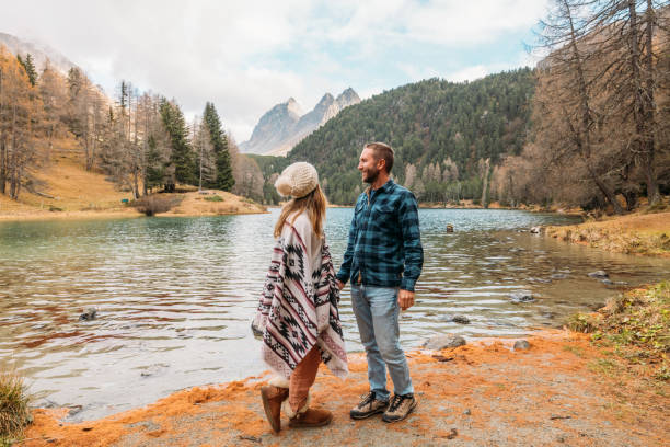 istock Couple Holding Hands by a Tranquil Mountain Lake 2185323366