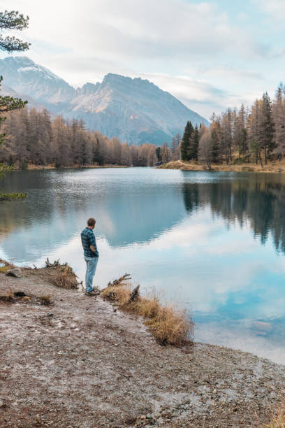 istock Man Reflecting by Mountain Lake 2185323555
