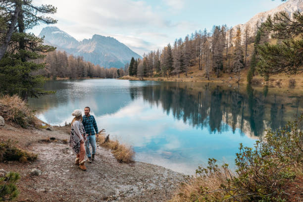 istock Couple Admiring Mountain Lake Scenery 2185323586
