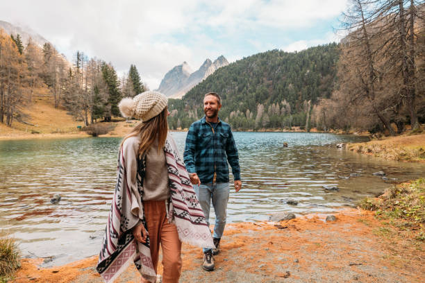 istock Couple Holding Hands by a Tranquil Mountain Lake 2185324261