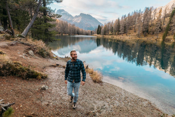 istock Man Walking by Mountain Lake in Autumn 2185324313