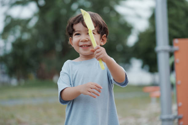 istock Cute Asian boy having fun while playing on the playground on sunny day. Outdoor activity. 2185325468