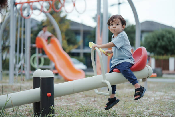 istock Cute Asian boy having fun while playing on the playground on sunny day. Outdoor activity. 2185325743