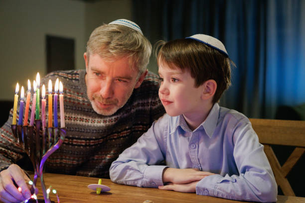 istock 55 year old man celebrates Hanukkah with his son 2185327448