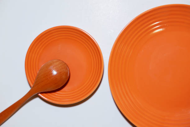 istock Orange plates and wooden spoon. 2185327472