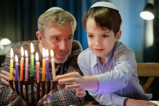 istock 55 year old man celebrates Hanukkah with his son 2185327497