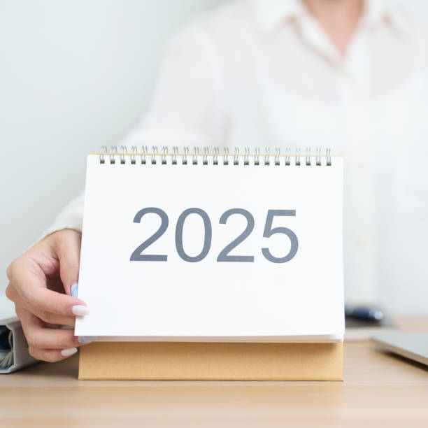 istock 2025 Year Calendar on table with business woman using laptop computer, working and writing in office. countdown, Happy New Year, Resolution, Year End and New Start and Goals Plan Action Concept 2185329563
