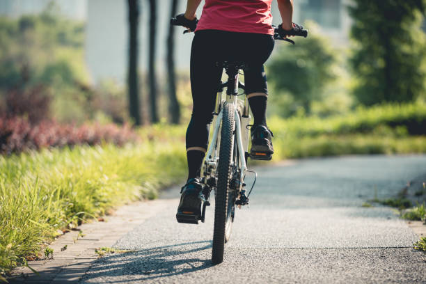istock Woman riding mountain biking in sunny park 2185330084