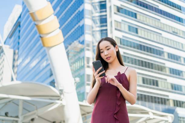 istock Young Asian Woman Using Smartphone in Urban Business District 2185331378