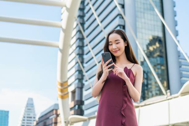 istock Young Asian Woman Using Smartphone in Urban Business District 2185331385