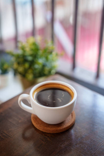 istock Hot Black Coffee in a White Cup on a Wooden Table 2185332358