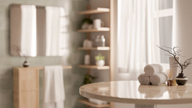 istock A round table features towels and decor objects with a blurred background of a clean bathroom. 2185334619