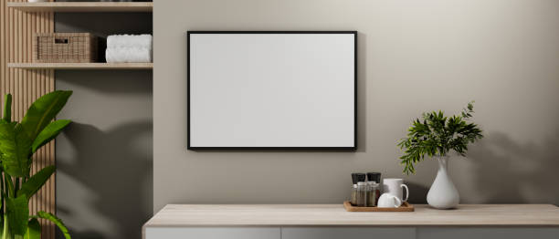 istock A blank picture frame mockup mounted on a grey wall in a contemporary room corner. 2185334622