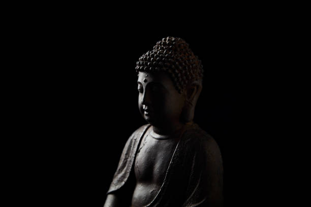 istock Meditating Buddha Statue on dark background. Close up. Copy space. 2185335236
