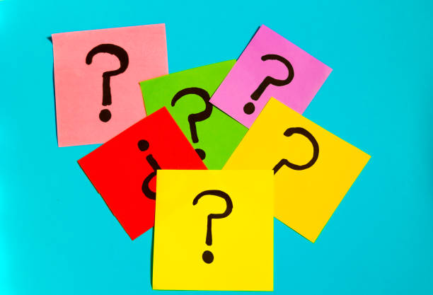 istock Top view of multi colored sticky papers with drawn question marks scattered on blue background 2185338034
