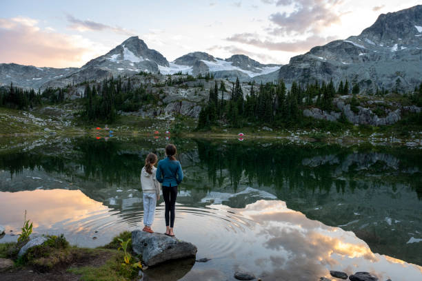 istock Sisters stand on lakeshore at sunset 2185338362