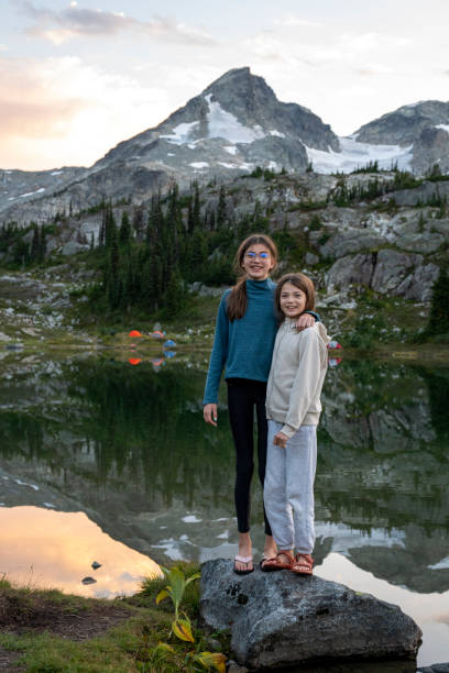 istock Sisters stand on lakeshore at sunset 2185338501