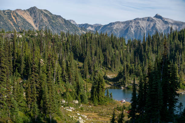 istock Elevated view of tent on lakeshore below mountain 2185339188