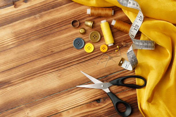 Crafting tools and materials arranged on a wooden table for sewing projects