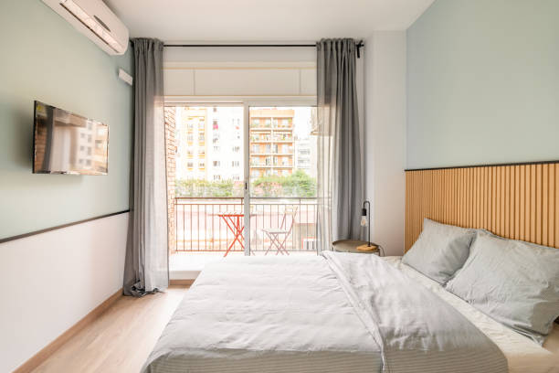 istock Spacious bright room with bed, large opening on entire wall with sliding plastic doors and access to balcony. Room has table with chair, air conditioning and TV for pleasant leisure. 2185342370