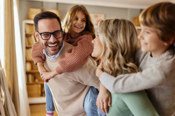 istock Happy family having fun while piggybacking at home. 2185343737