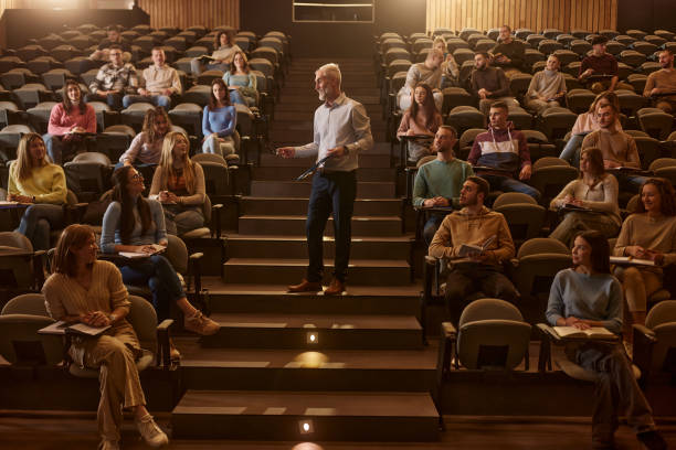 istock Happy senior professor teaching his students in lecture hall. 2185345197