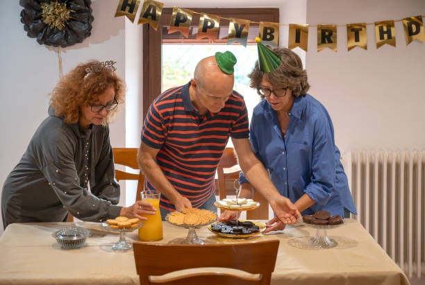istock three middle-aged friends setting the table for a surprise birthday party 2185347876
