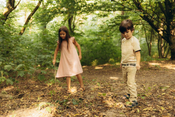 A little girl in the forest walking with a boy