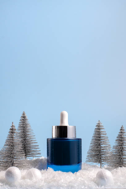 istock Winter skincare beauty concept with face serum on a blue background, front view 2185349801