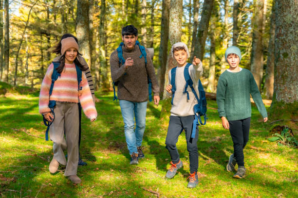 istock Boy pointing ahead while trekking with the family at forest 2185349818