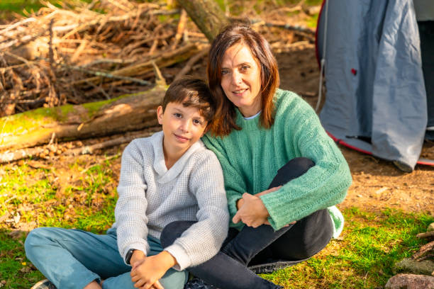 istock Mother and son smiling at camera sunbathing enjoying nature 2185351381