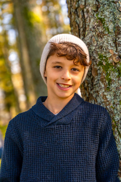 istock Teenager with urban hat leaning in a tree trunk 2185351409