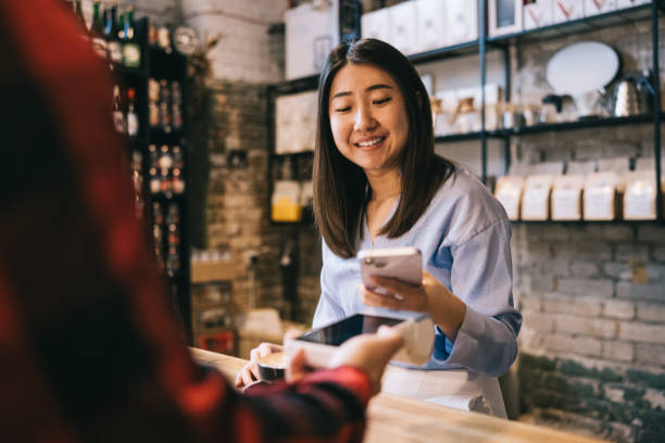 istock Businesswoman making a mobile payment at a cafe 2185352106