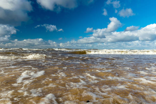 beautiful seascape with sea waves crashing on the shore and exploding, beautiful blue skies and white clouds over the sea, Vidzeme rocky seashore, Salacgriva rural area, Latvia