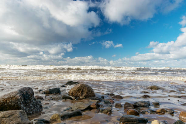 beautiful seascape with sea waves crashing on the shore and exploding, beautiful blue skies and white clouds over the sea, Vidzeme rocky seashore, Salacgriva rural area, Latvia