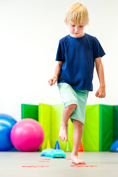 Kids physical therapy. Child exercising during session. Bilateral coordination is the ability to use both sides of the body together in a coordinated way.