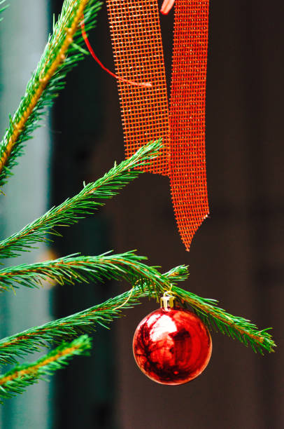Christmas tree decorated with bright red balls and red fabric bows, background for Christmas concept.