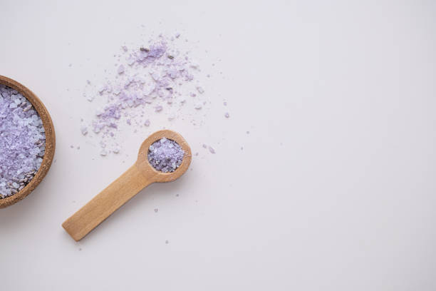 Lavender bath salt in wooden spoon, top view.