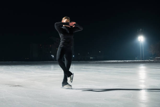 istock Beautiful young woman ice skating and performing short program 2185357366