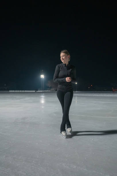istock Beautiful young woman ice skating and performing short program 2185357374